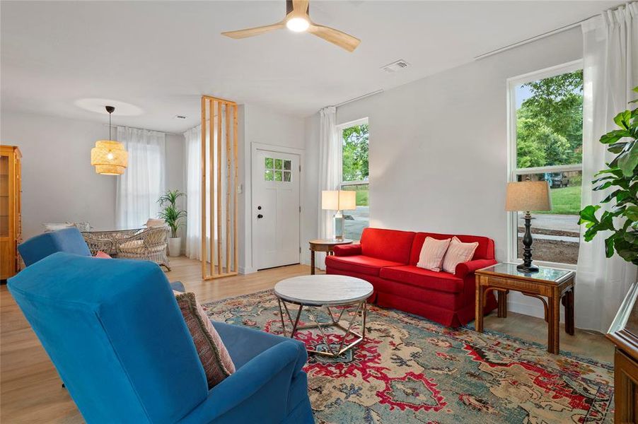 Living room with ceiling fan and hardwood / wood-style floors