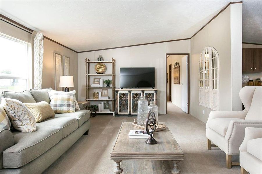 Carpeted living room featuring a textured ceiling, crown molding, and vaulted ceiling