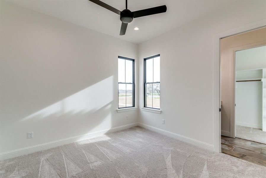 Unfurnished bedroom featuring ceiling fan, a closet, and light colored carpet