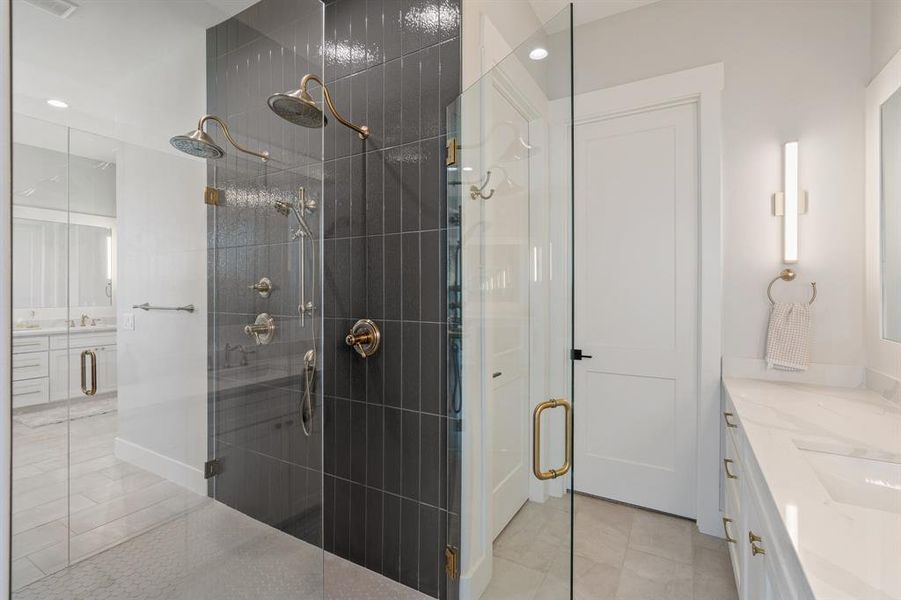 Bathroom with a shower with shower door, vanity, and tile floors