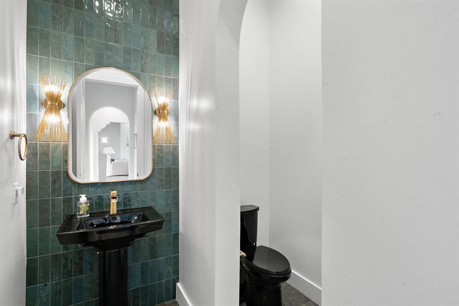 Bathroom with decorative backsplash, tile walls, toilet, and tile patterned flooring