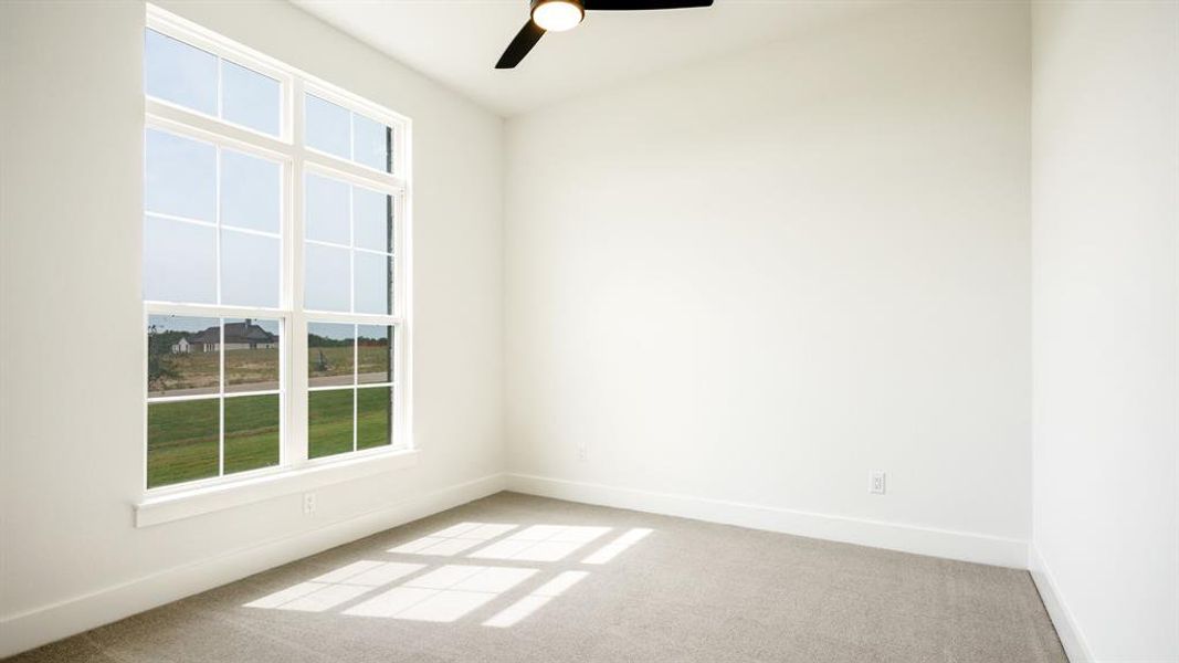 Carpeted empty room featuring ceiling fan