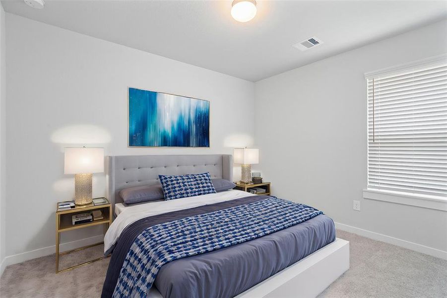 Secondary bedroom features plush carpet, custom paint, lighting, and a large window with privacy blinds.