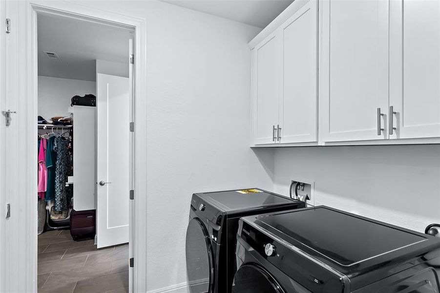 The utility room is perfectly located off the kitchen and hall, but also flows straight into the primary closet and comes with overhead cabinets and an additional storage closet.