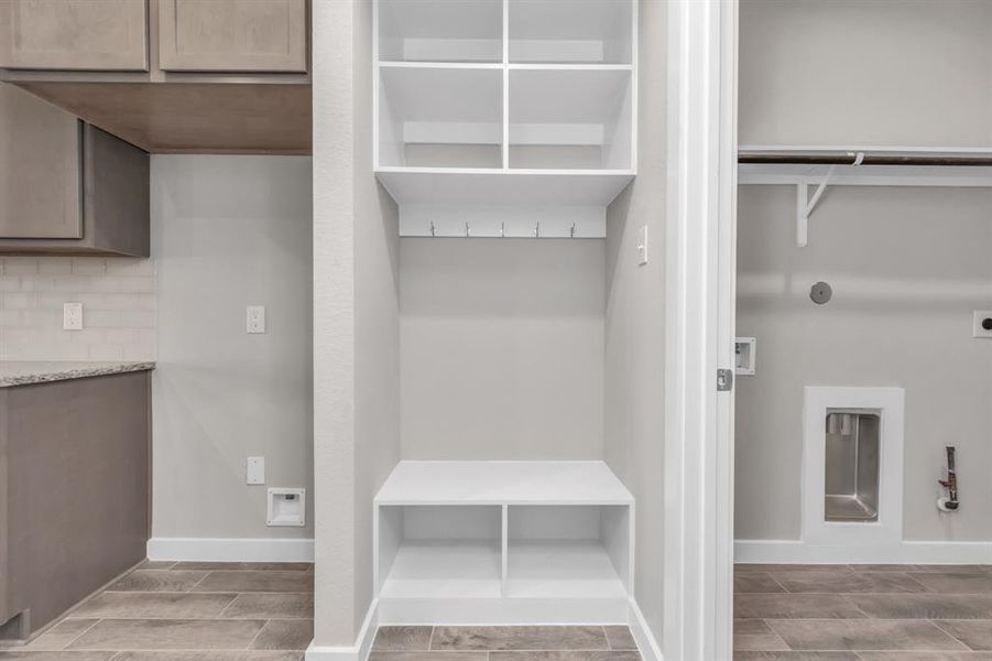 Utility room, conveniently positioned next to a built-in highly functional mudroom. Functionality with a touch of style with this upgrade. Sample photo of completed home with similar floor plan. As-built interior colors and selections may vary.
