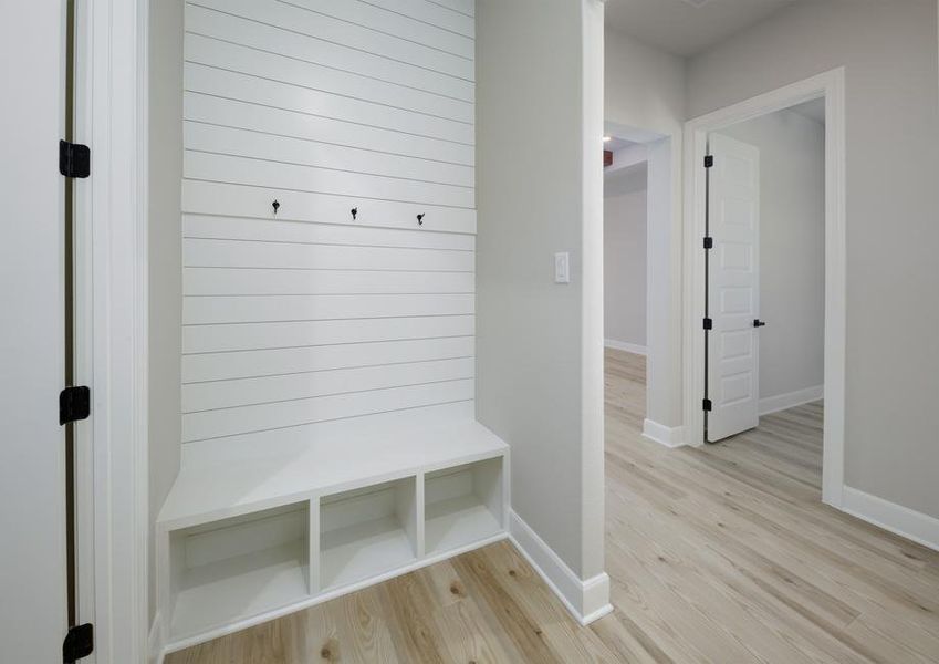 The mudroom has a built-in storage bench with shiplap details.