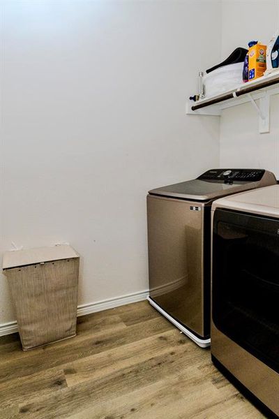 Clothes washing area featuring light hardwood / wood-style floors and independent washer and dryer