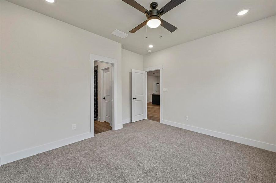 Unfurnished bedroom with ceiling fan and carpet floors