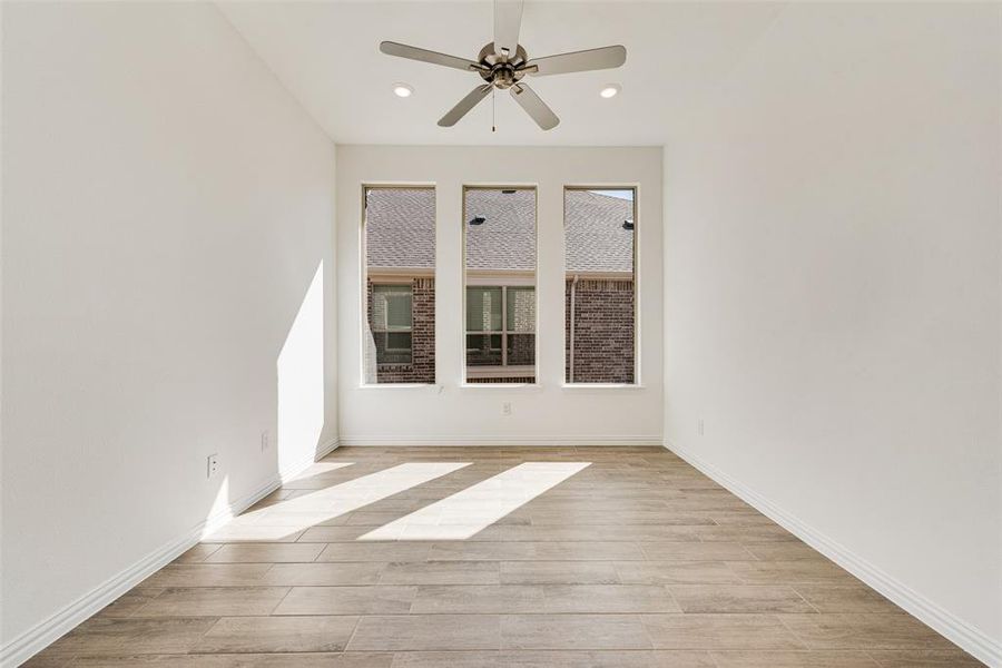 Unfurnished room with light hardwood / wood-style floors and ceiling fan