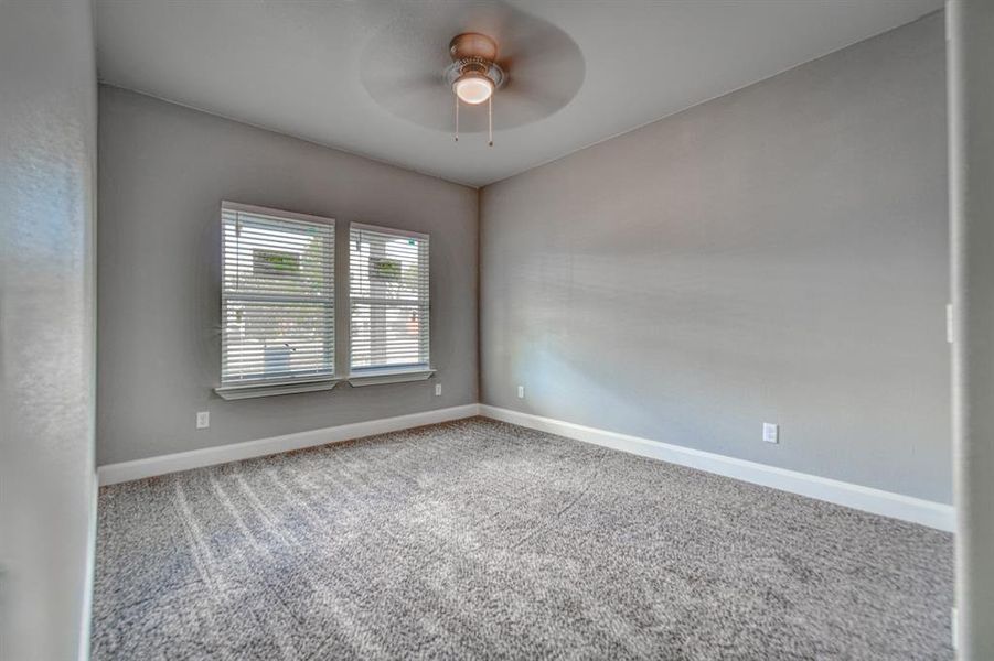 Carpeted spare room with ceiling fan