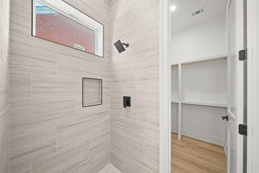 It features a gorgeous walk-in shower with beautiful tile up to the ceiling and a spacious walk-in closet. *shower glass installation coming soon* Photos are from a similar unit in the development.