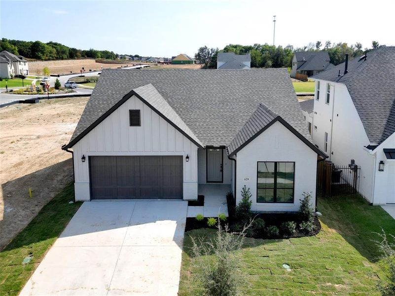 View of front of property featuring a front yard and a garage