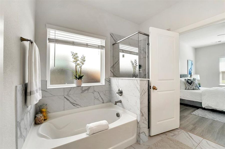 Bathroom with plenty of natural light, hardwood / wood-style floors, and shower with separate bathtub