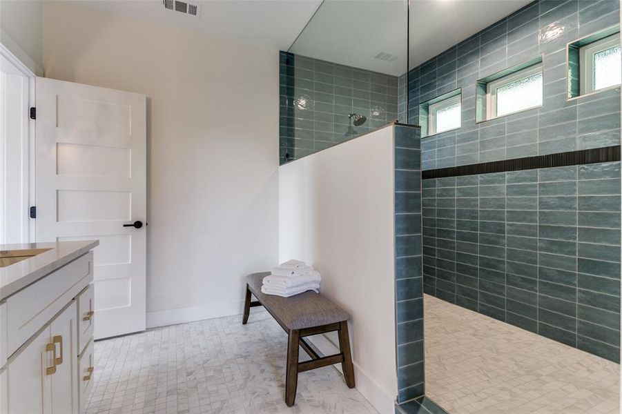 Bathroom featuring tiled shower, tile floors, and vanity