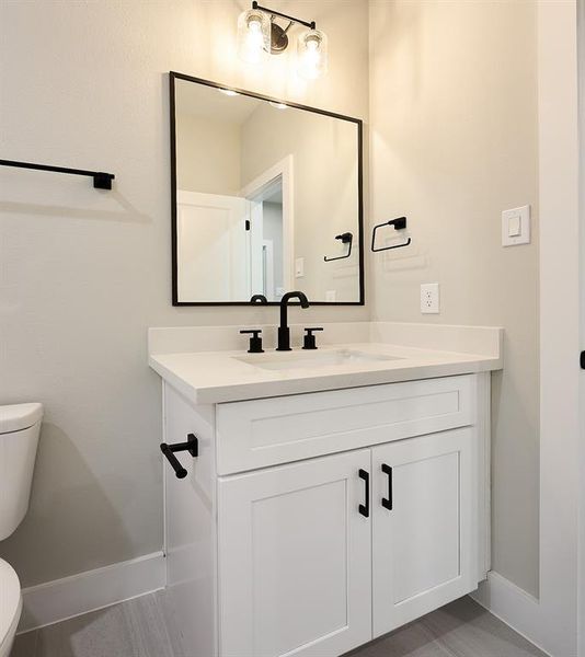 Secondary bathroom with shaker cabinets and quartz counter-tops.