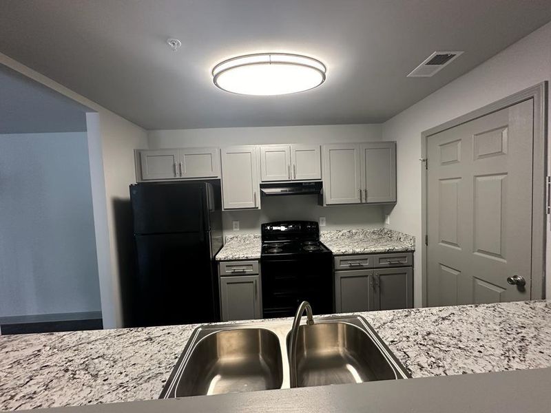 Kitchen featuring black appliances, sink, and gray cabinets