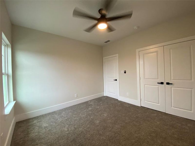 Unfurnished bedroom with carpet flooring, a closet, and ceiling fan