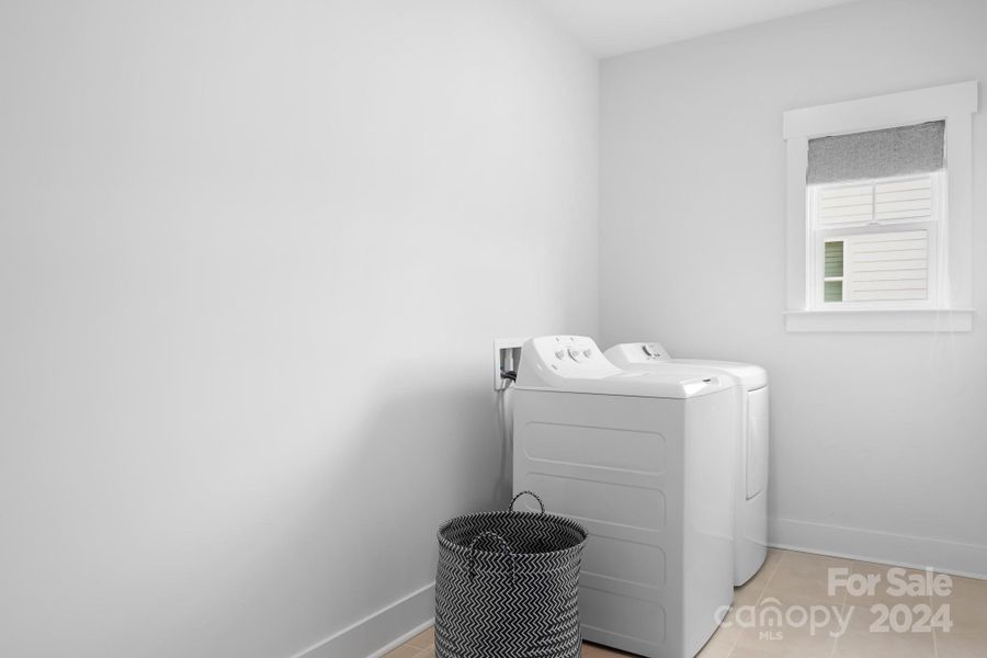 Very large laundry room with a window to let in natural light.  Floor is tile.