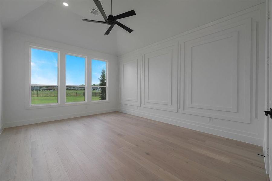 Empty room featuring light hardwood / wood-style floors, ceiling fan, and vaulted ceiling