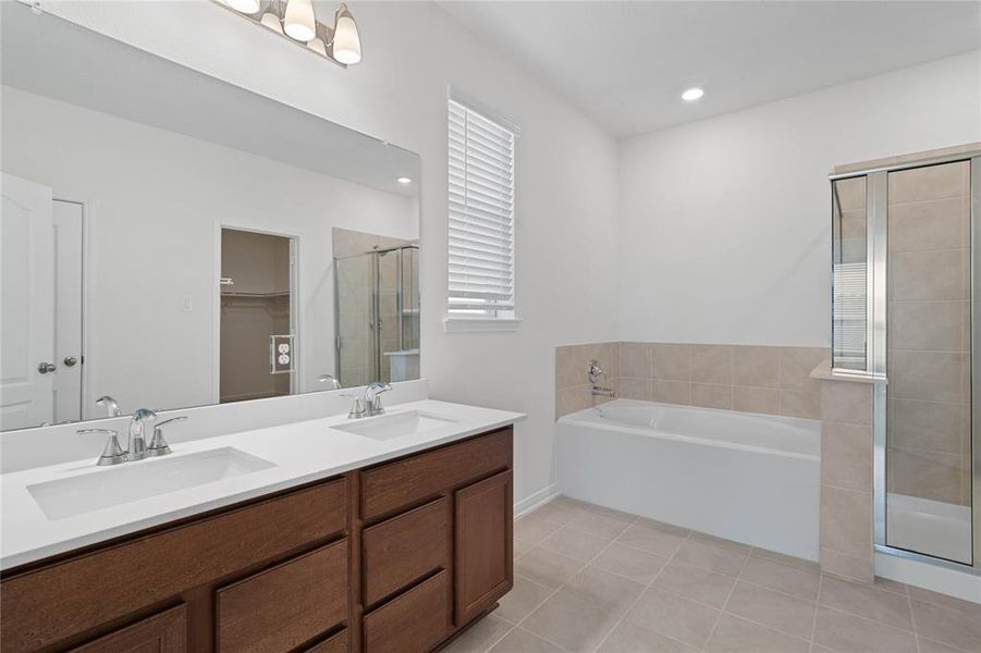 This large primary bath is spacious enough to share! With separate vanities, plentiful cabinet and counter space, you are sure to have private area while sharing this bathroom!