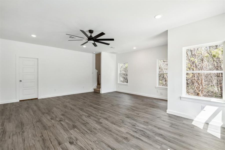 Unfurnished living room featuring ceiling fan and wood-type flooring