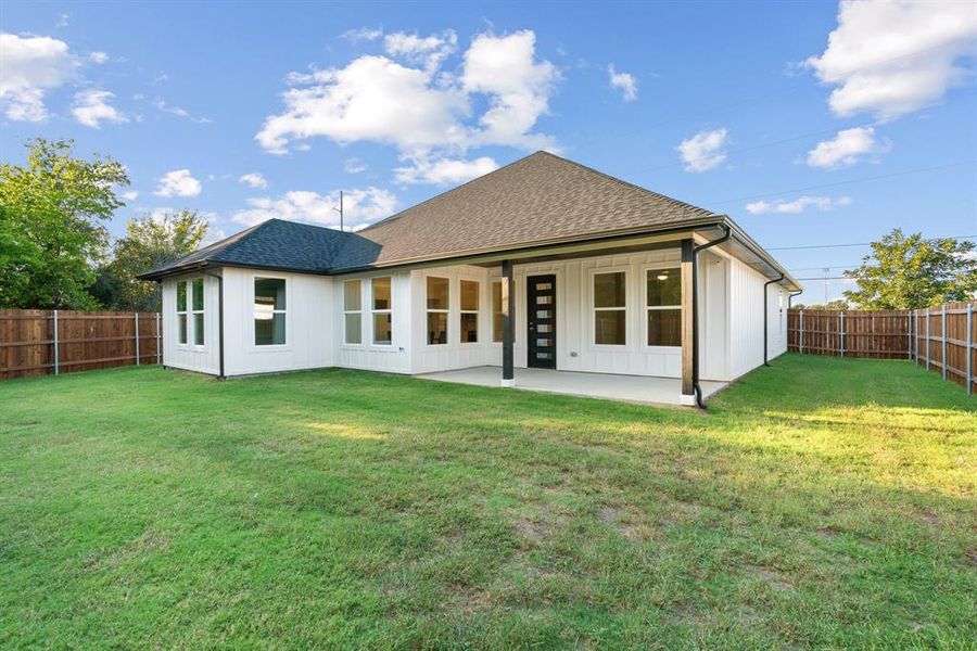 Back of property featuring a patio and a lawn