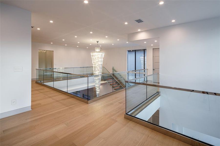 Repeating the amazing finishes of the first floor, the second floor landing displays similar elegance and sophistication. Features glass railing and wide plank wood floors