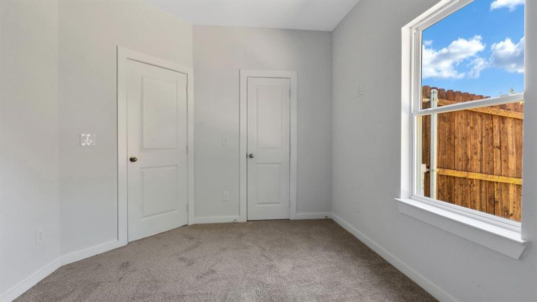 Unfurnished bedroom with light carpet