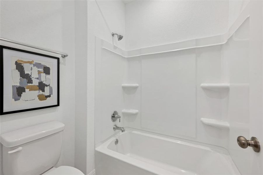 Combination tub/shower and toilet are separated by a door from double vanities.