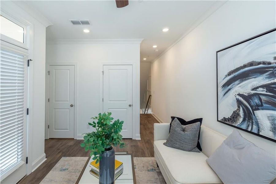 Sun  room featuring dark hardwood / wood-style floors, ceiling fan, and ornamental molding, not the actual unit