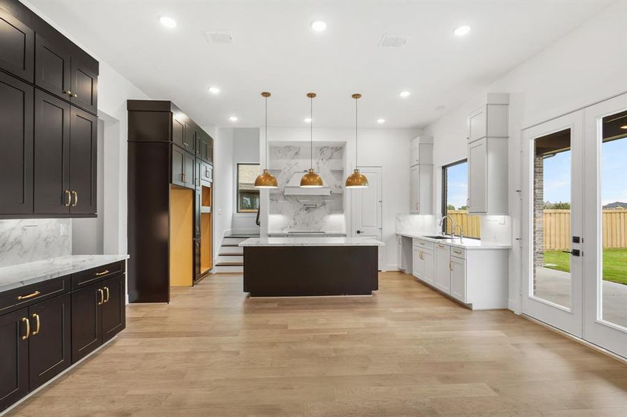 This kitchen is an entertainers dream come true! Sizeable island, perfect for gathering. Stacked cabinets and porcelain counters add an elegant touch!