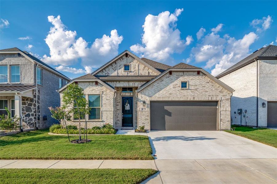 View of front of property with a garage and a front lawn