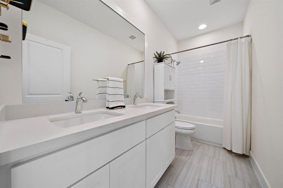 A well-appointed secondary bathroom featuring dual sinks - a convenient and stylish addtion for your family or guests.