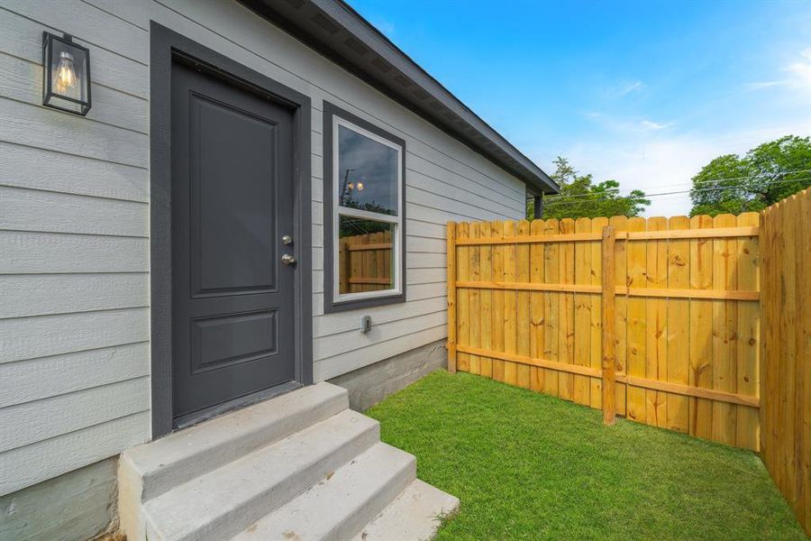 Doorway to property featuring a yard