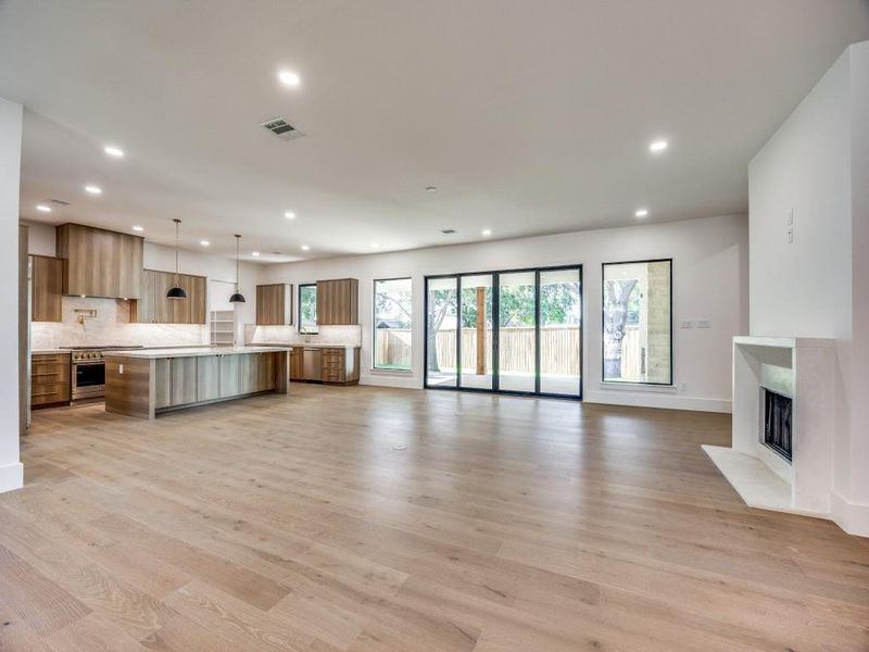 Unfurnished living room featuring light wood-type flooring and a high end fireplace