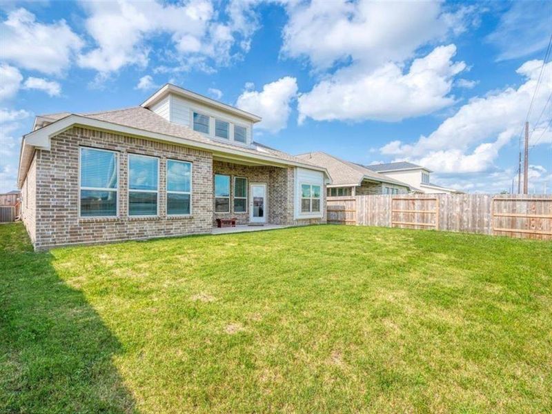 Create your own private oasis in this tranquil backyard. The secure fence ensures privacy, while the vastness of the space and clear blue sky promote a sense of peace and serenity.