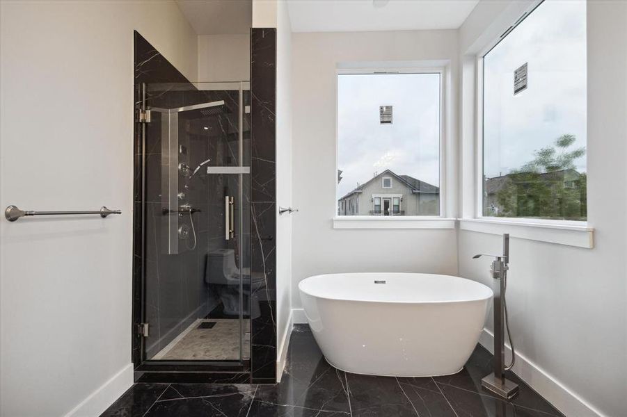 Primary suite bath with walk-in shower and free standing tub