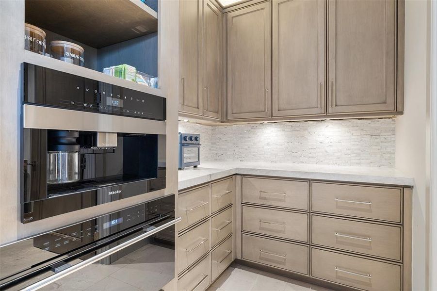 Admire the sleek cabinetry that lines the walls of the kitchen, providing ample storage space for cookware, utensils, and pantry essentials, while adding a touch of modern sophistication to the space.