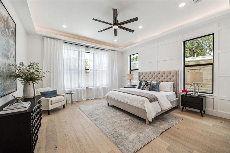 Calling all fans of first-floor living! This 18 x 17 wood-paneled primary suite, perfectly situated on the main floor, lets you wake up to beautiful views of the lush, turfed backyard and sparkling pool. PS! Tray ceiling with ambient lighting.