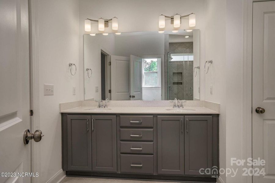 Concept photo of Primary Bath with dual vanity, walk in shower, water closet & tile floors!