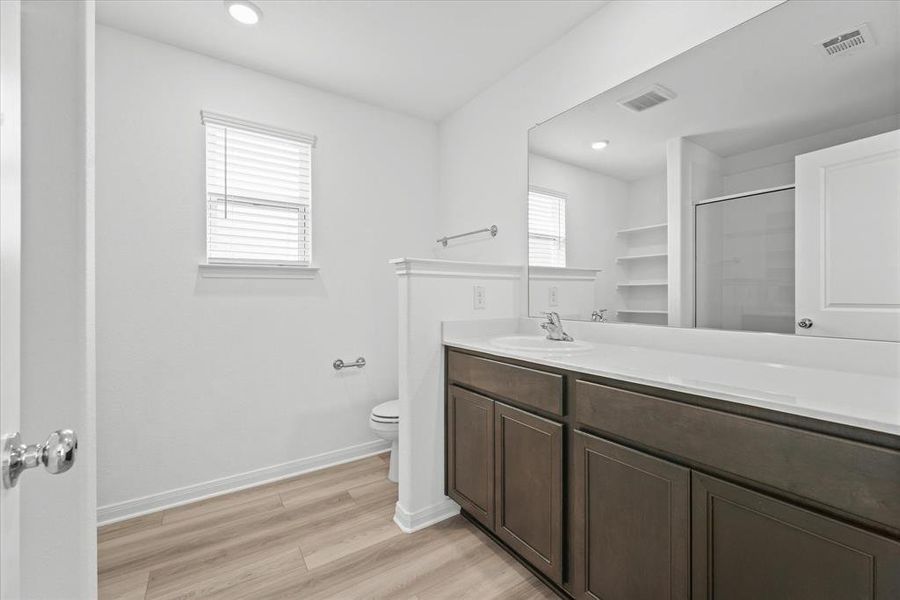 Bathroom featuring hardwood / wood-style flooring, toilet, and vanity