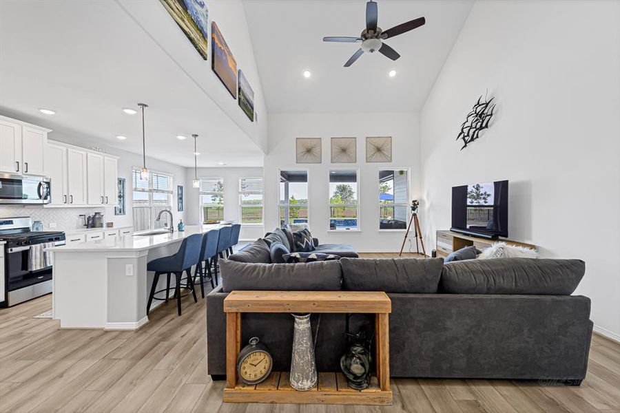 This lovely home features an inviting open floor plan with luxury vinyl plank floors and a wall of windows to allow a picturesque view of the pristine pool and covered patio.