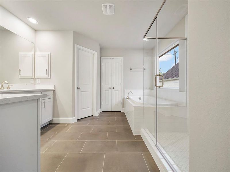 Step into the spa-like Primary Bath! The space features two vanities, custom cabinets, and stunning quartz countertops. ** 1511 Auline will have a free-standing bathtub (Sample photo of a completed Sterling Floor Plan. Image may show alternative features/and or upgrades.)