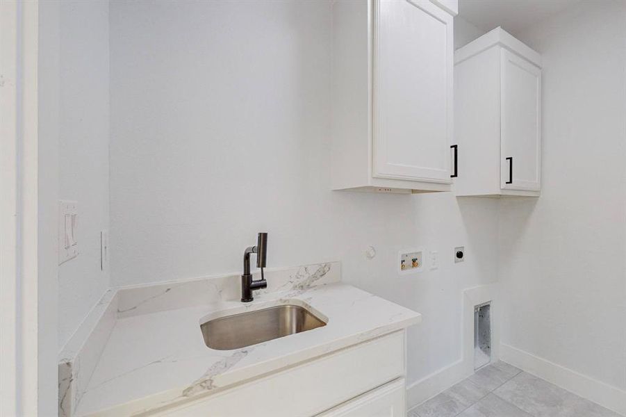 Laundry room with light tile patterned flooring, sink, electric dryer hookup, cabinets, and washer hookup