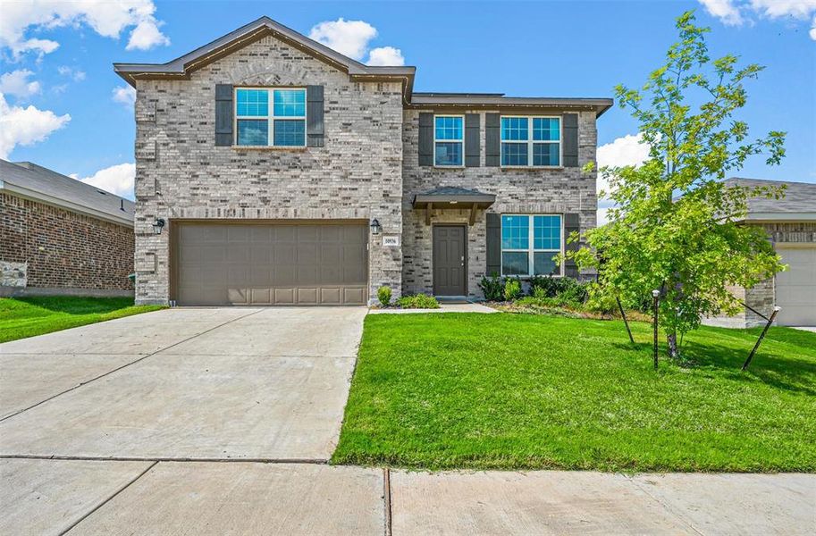 View of front of home featuring a garage and a front lawn