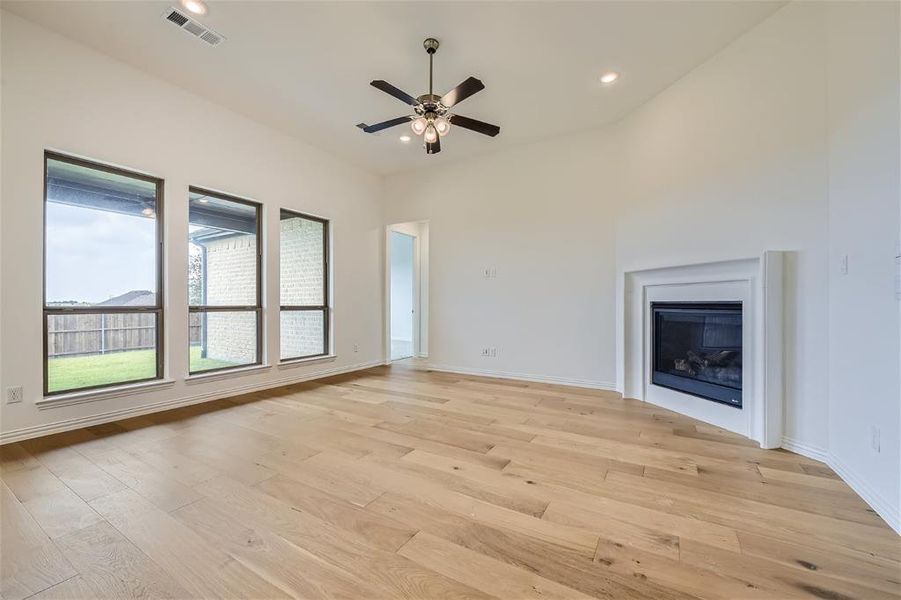 Unfurnished living room featuring ceiling fan and light wood-type flooring