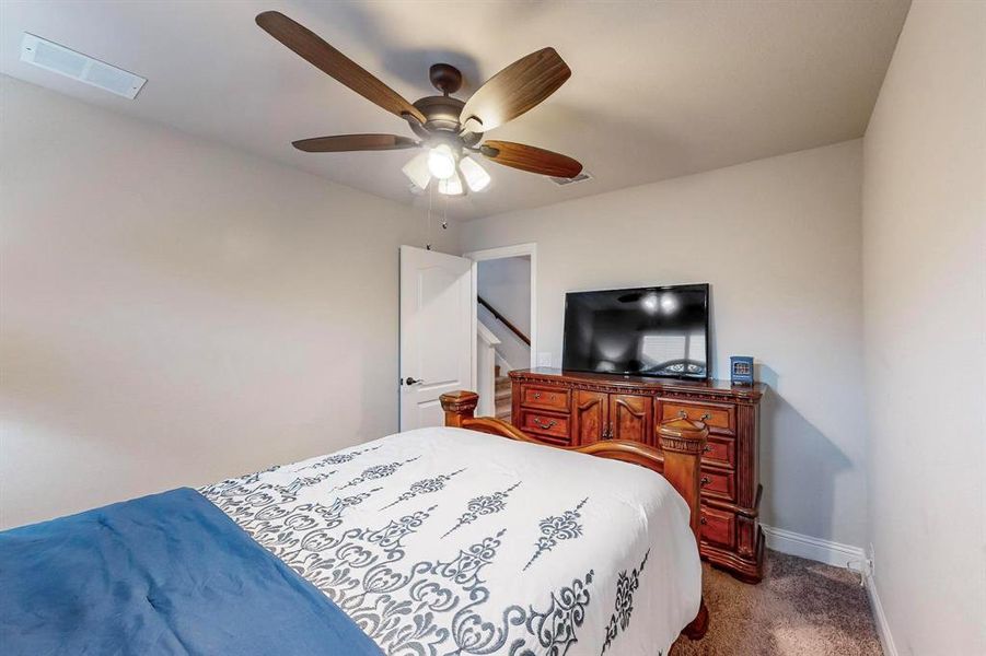 Bedroom featuring dark carpet and ceiling fan