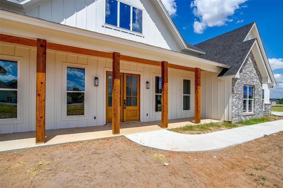 Doorway to property featuring covered porch