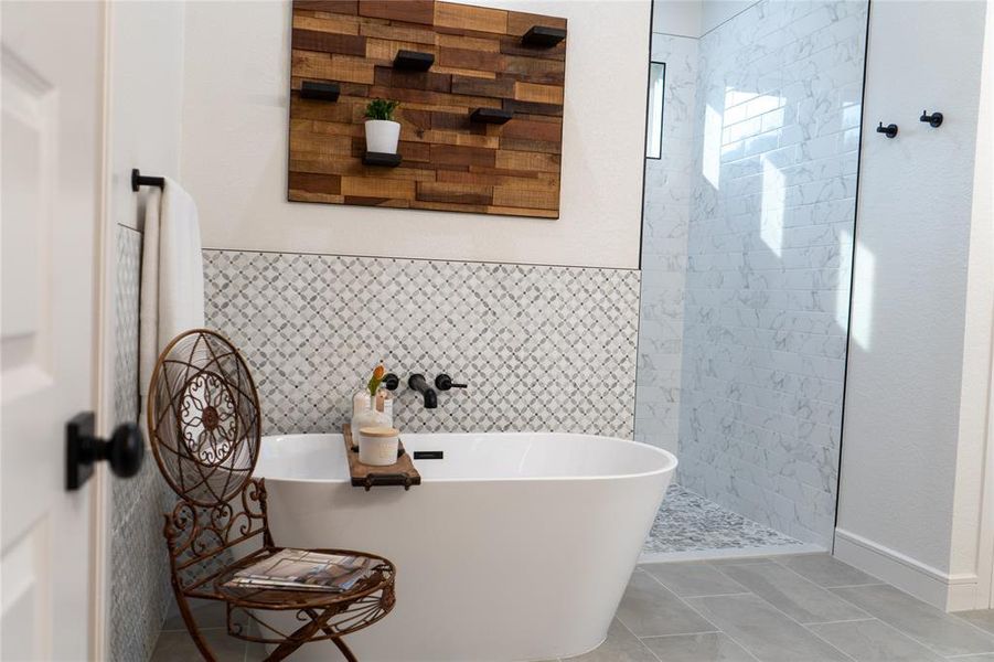 Bathroom featuring tile patterned floors, tile walls, and plus walk in shower