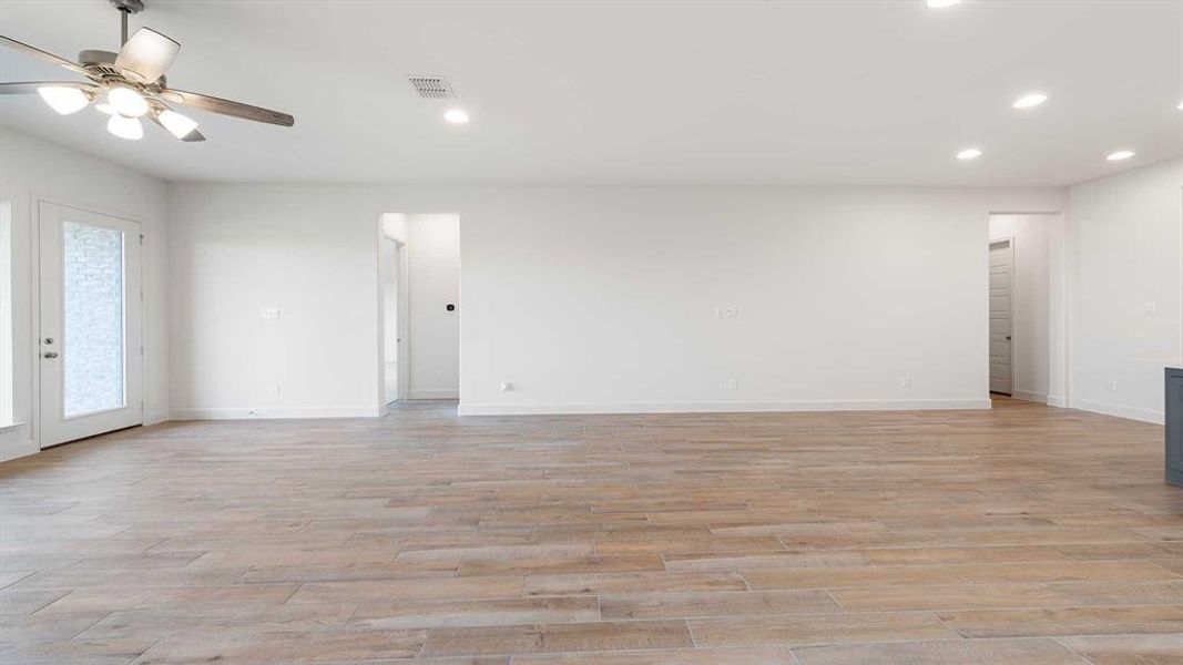 Empty room with light hardwood / wood-style floors and ceiling fan